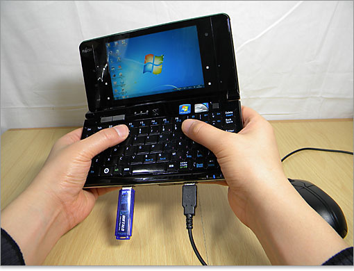 モバイル用途でこのような持ち方をするためです。邪魔にならない位置を考慮しています。